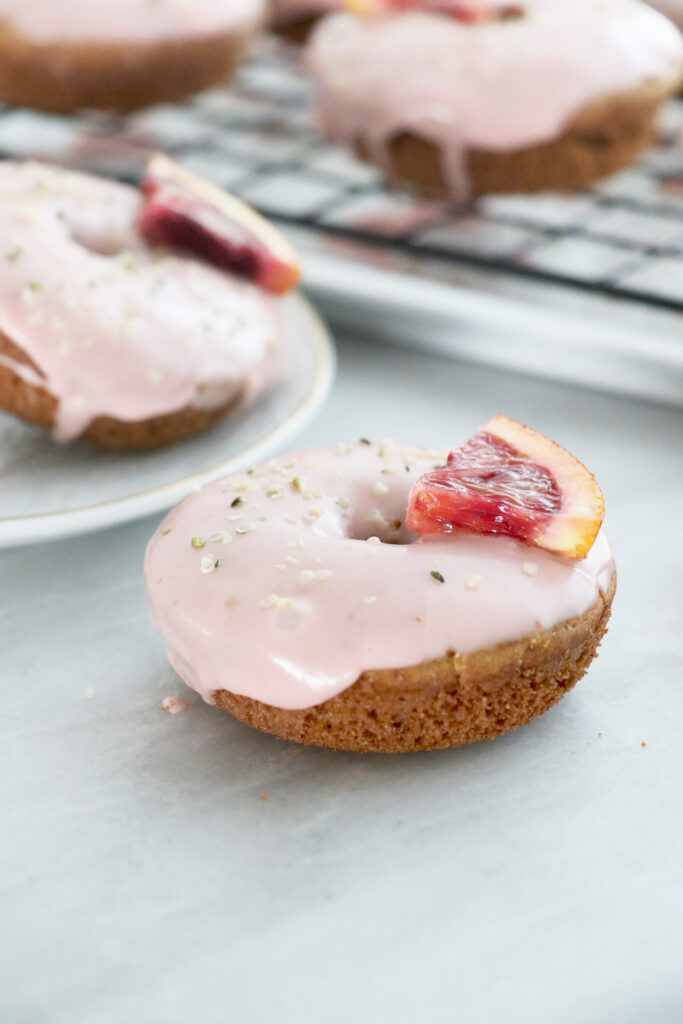 Donuts with blood orange pink icing and triangle wedges on donuts.